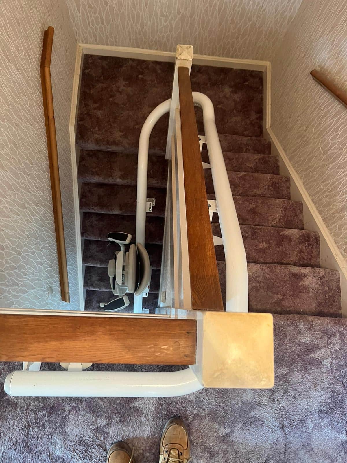 Curved staircase with stairlift rail looking down from the top of the stairs