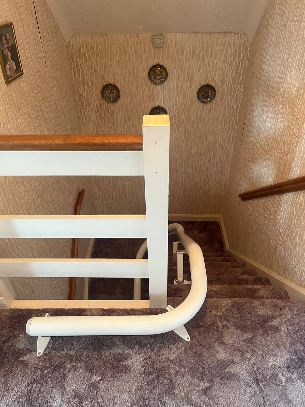 Stairlift rail at the top of a curved staircase