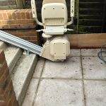 External stairlift at the bottom of outside steps in the folded up position