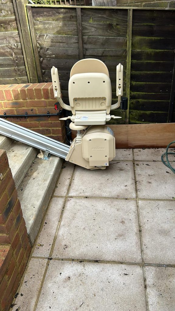External stairlift at the bottom of outside steps in the folded up position