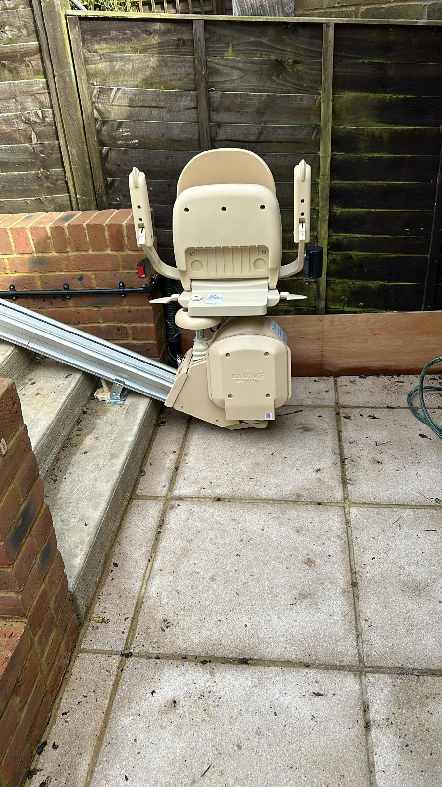 External stairlift at the bottom of outside steps in the folded up position