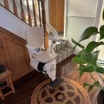 Curved stairlift in its ready position at the bottom of curved staircase