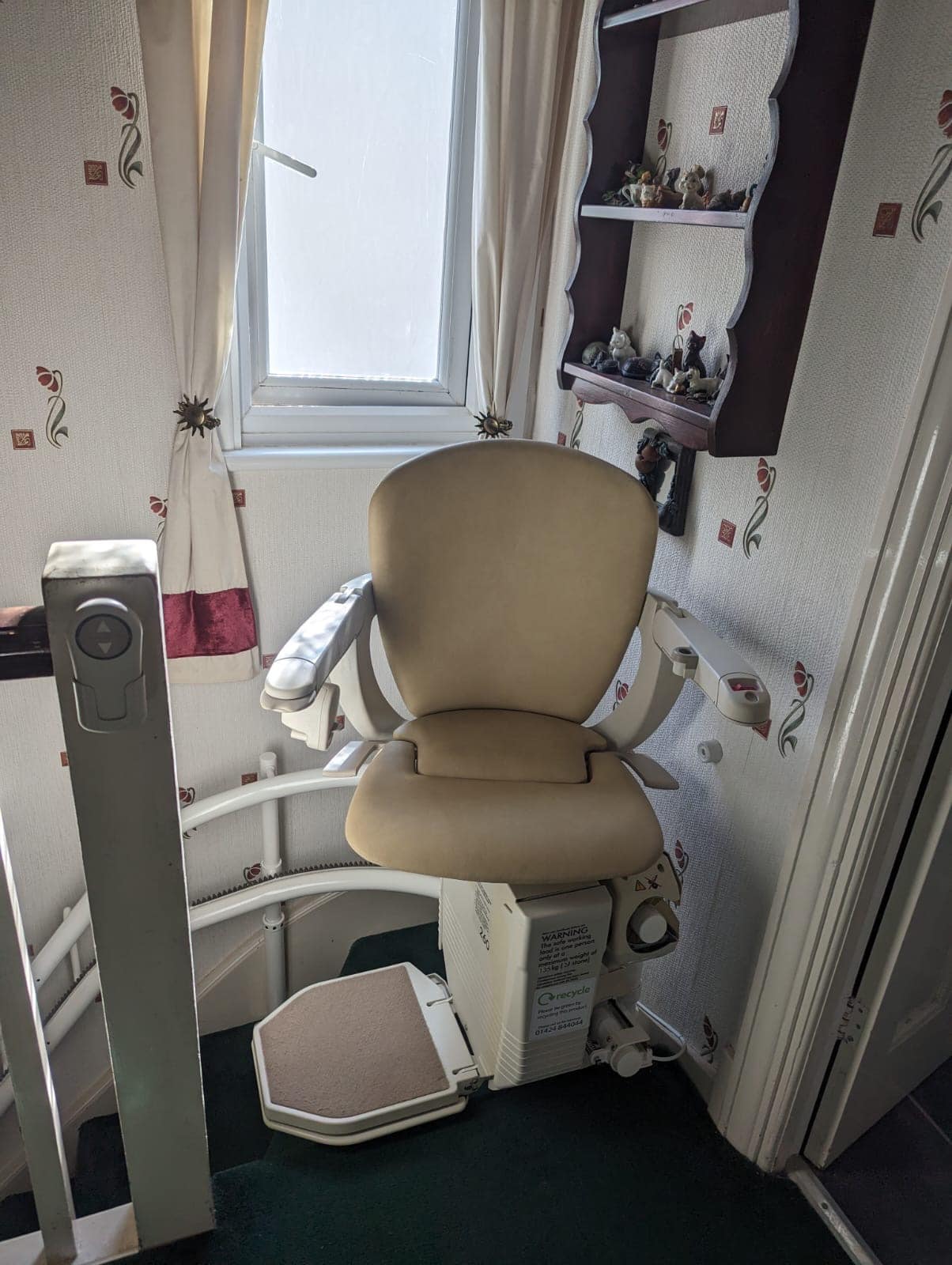 Prestige stairlift on twin rail with beige seat at the top of stairs