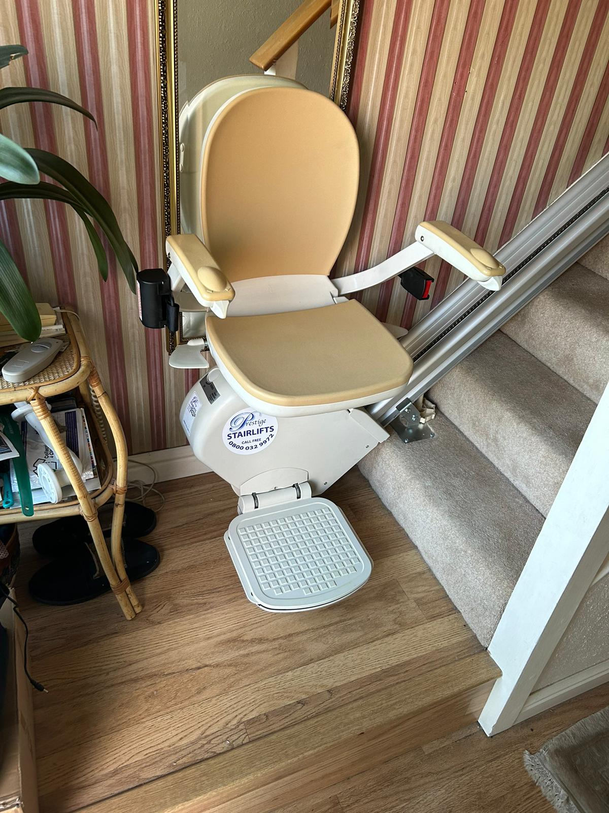 Stairlift in its ready position parked at bottom of stairs