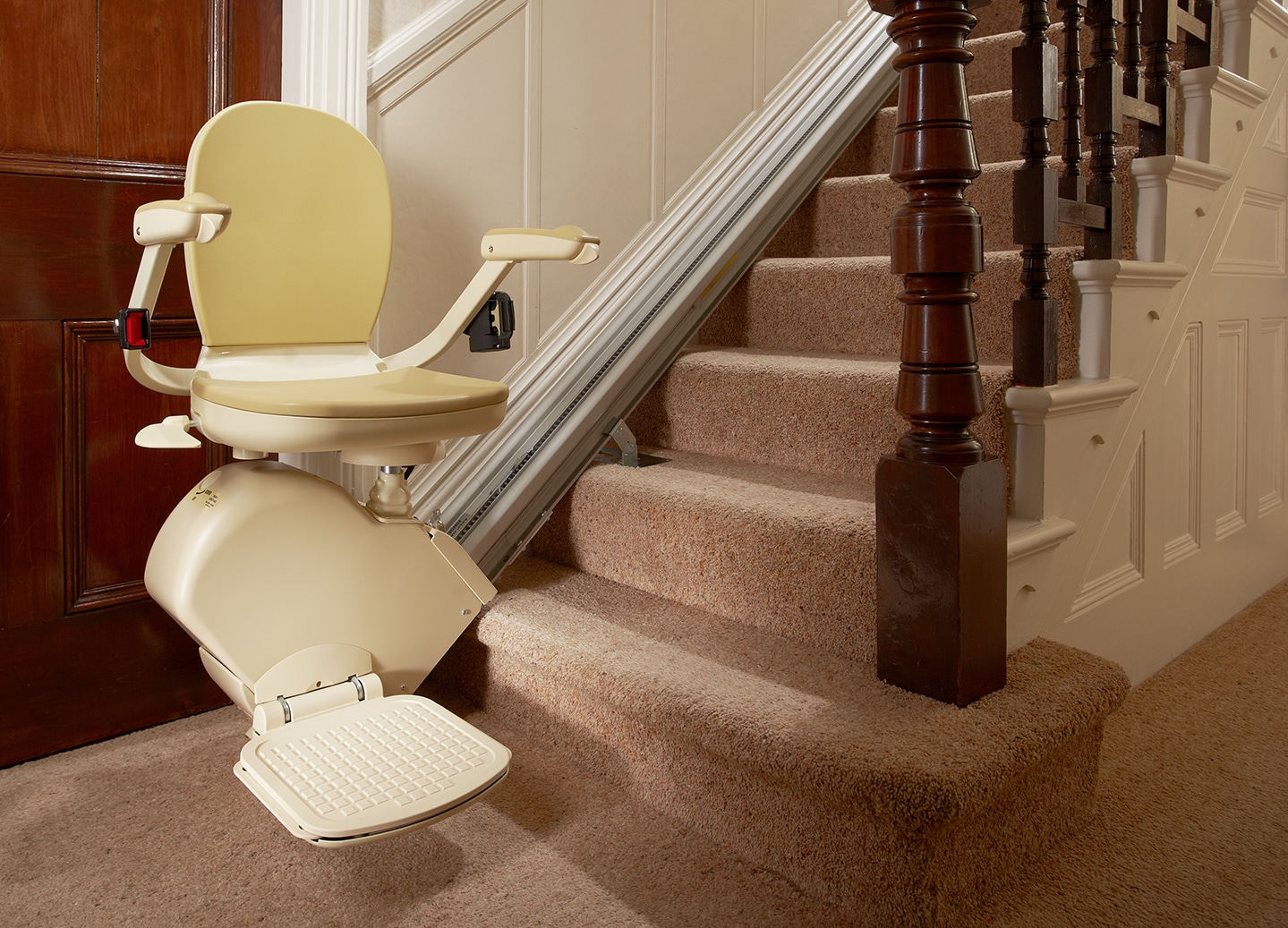 Prestige Brooks stairlift in ready position with footplate down at the bottom of a staircase