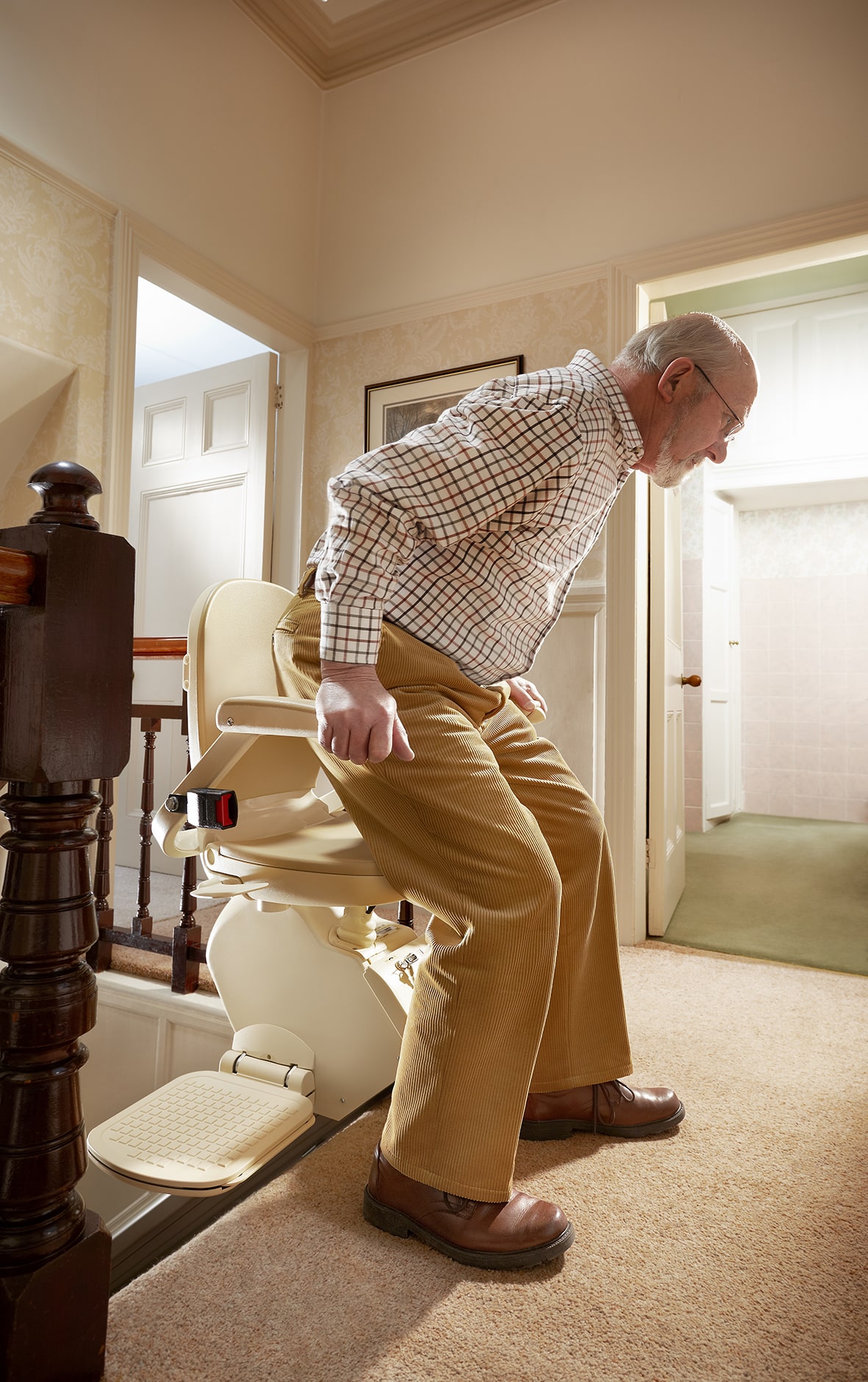 Demonstration of man getting off Prestige Brooks stairlift at the top of the stairs