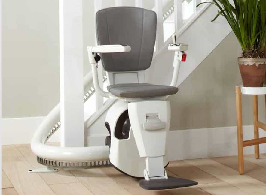Flow 2 stairlift in its ready position at the bottom of a curved staircase