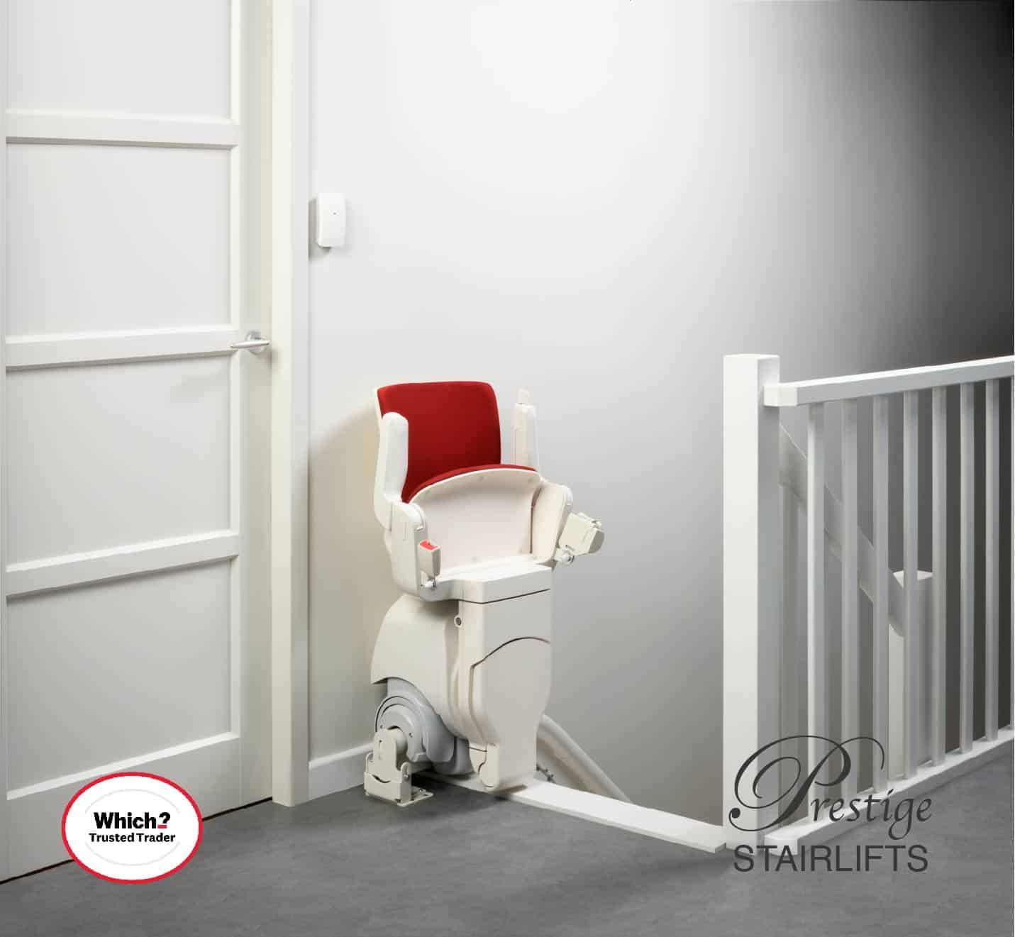 Otolift stairlift with red upholstered seat in its foldaway position at the top of the stairs