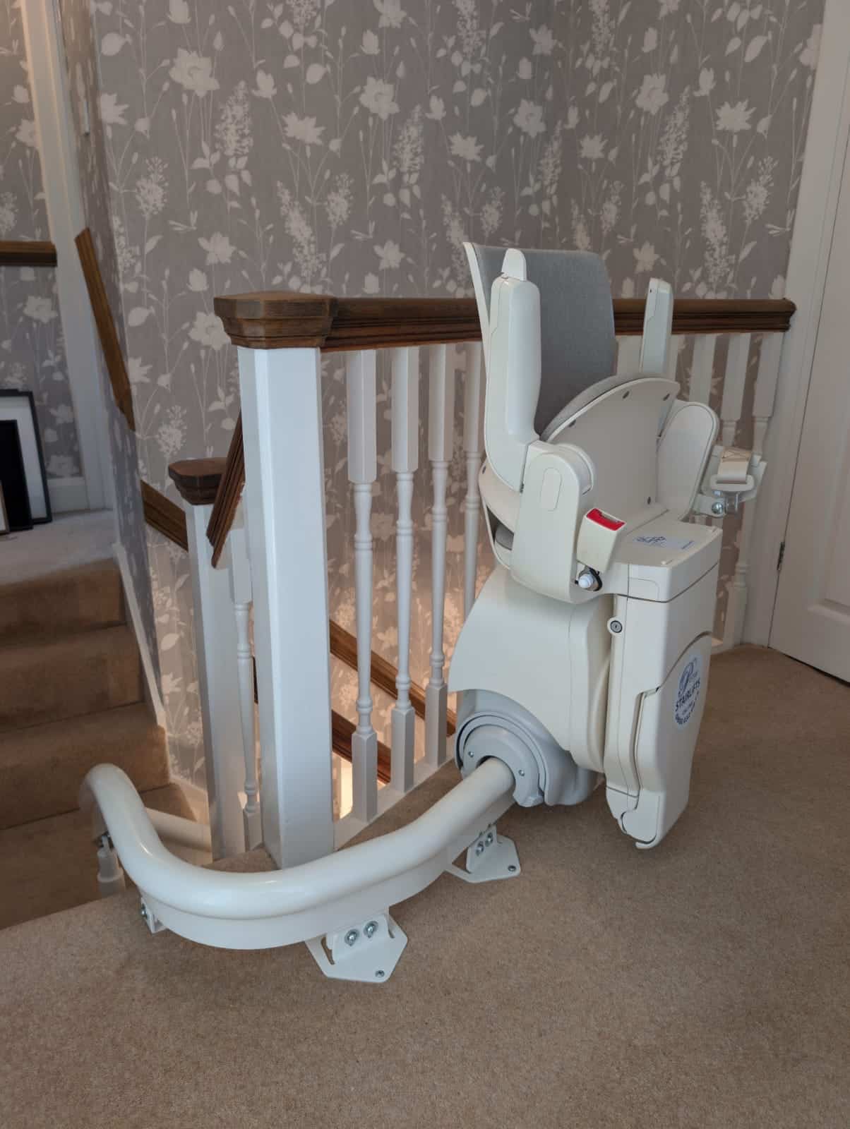 Otolift stairlift demonstrated from the side view in its folded position at the top of the stairs