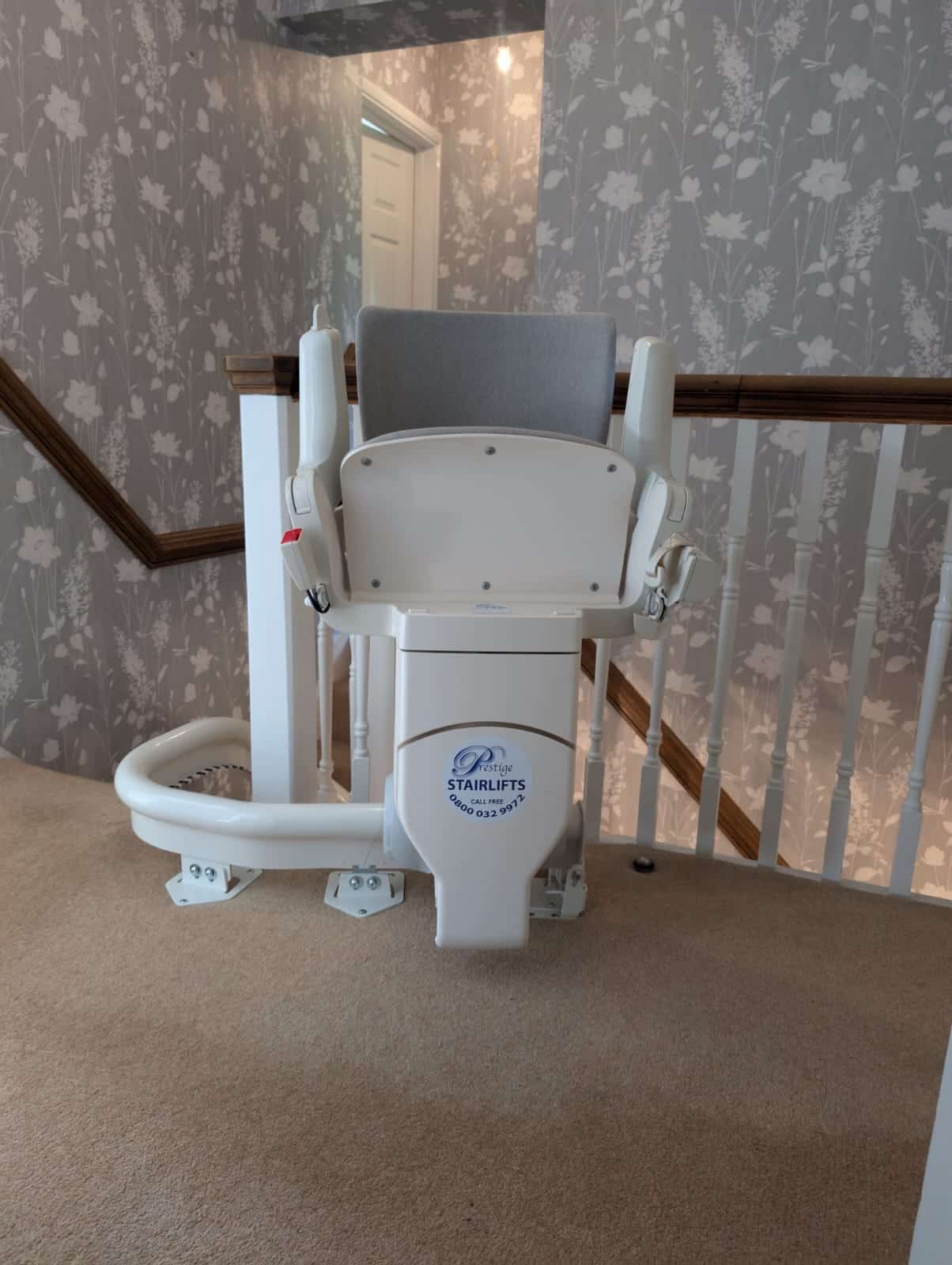 Otolift stairlift in its folded position at the top of the stairs