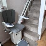 Platinum stairlift with grey seat in ready position clearly illustrating arm rest controls