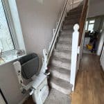 Platinum stairlift in folded position at the bottom of the stairs showing clearance on stairs
