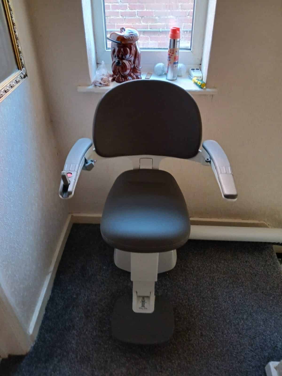 Flow stairlift in travel position at the top of the stairs