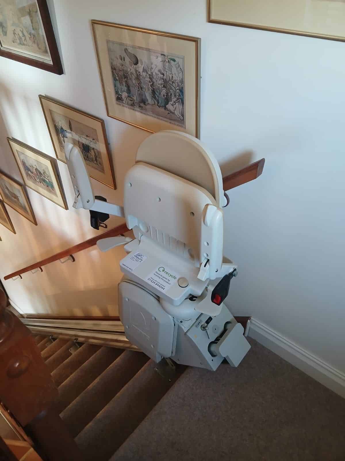 Stairlift in parked position at the top of a staircase