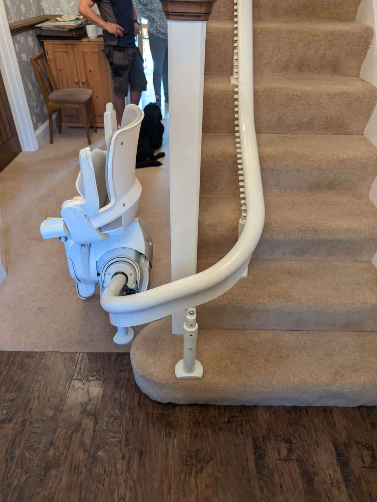 Curved rail going around the newel post at the bottom of the stairs