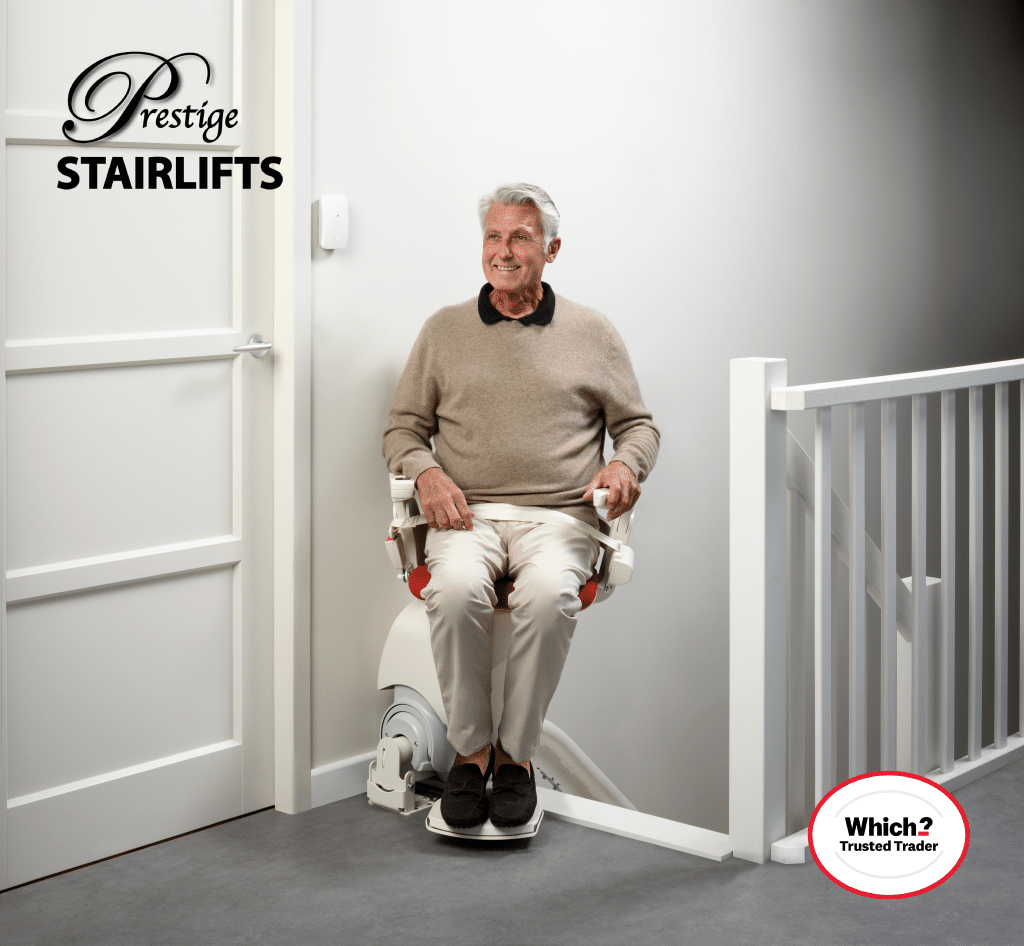 Man sitting on Otolift stairlift with seatbelt on at the top of the stairs